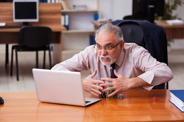 Old male employee in gambling concept at workplace — Stock Photo, Image