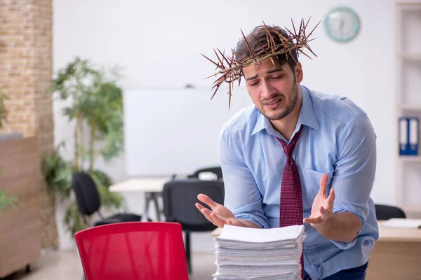 Junge männliche Angestellte trägt stacheligen Kranz auf dem Kopf — Stockfoto