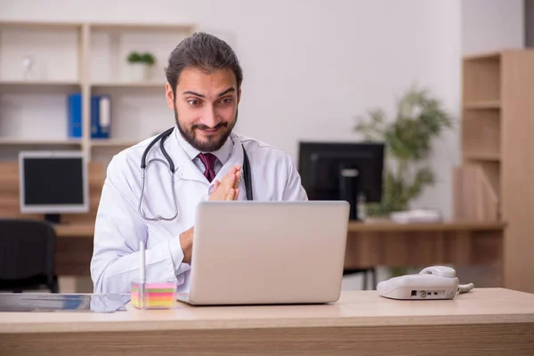 Jovem médico sentado no escritório — Fotografia de Stock