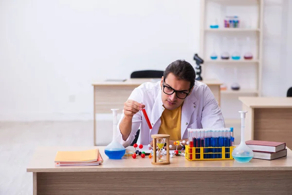 Joven químico masculino en concepto de gestión del tiempo — Foto de Stock