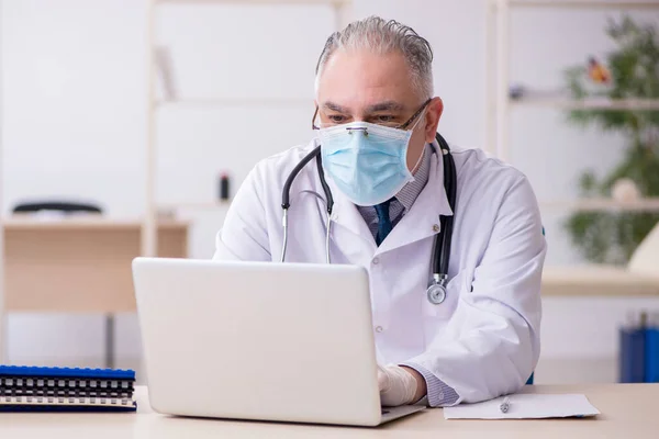 Vieux médecin masculin travaillant à la clinique — Photo