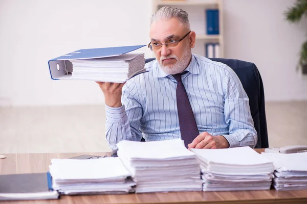 Старый бизнесмен недоволен чрезмерной работой в офисе — стоковое фото