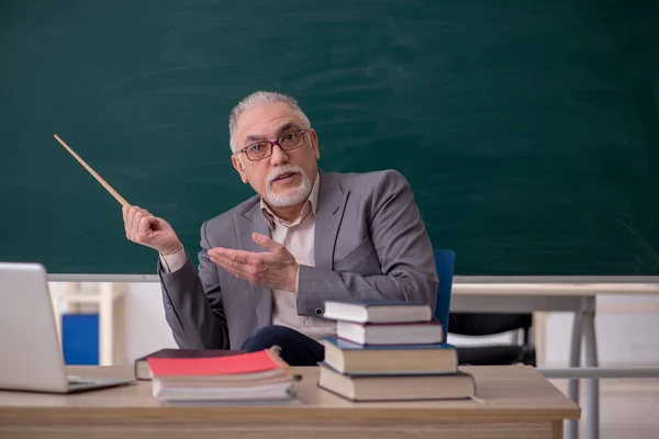 Oude mannelijke leraar voor schoolbord — Stockfoto