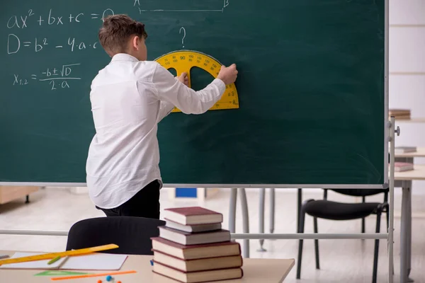 Écolier étudiant la géométrie devant le tableau noir — Photo