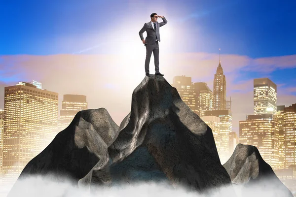 Uomo d'affari in cima alla montagna nel concetto di carriera — Foto Stock