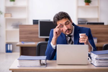 Molada kahve içen genç bir erkek.