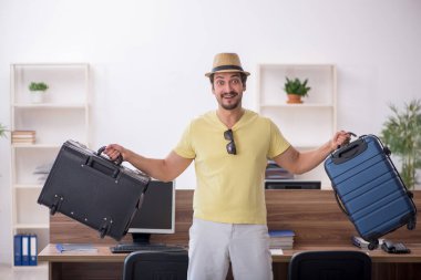 Genç bir erkek işçi iş yerinde geziye hazırlanıyor.