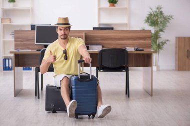 Genç bir erkek işçi iş yerinde geziye hazırlanıyor.