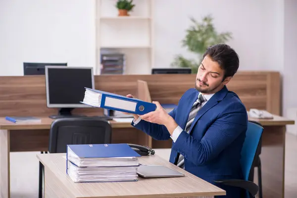 Junge männliche Mitarbeiter und zu viel Arbeit im Büro — Stockfoto