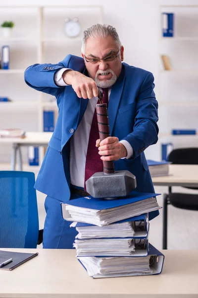 Alte männliche Angestellte unzufrieden mit zu viel Arbeit im Büro — Stockfoto