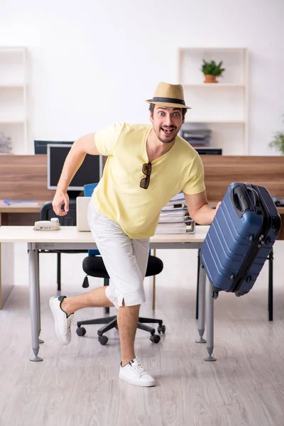 Ung manlig anställd förbereder sig för resa på arbetsplatsen — Stockfoto