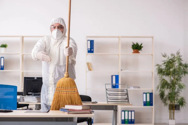 Empreiteiro velho limpando o escritório segurando vassoura — Fotografia de Stock