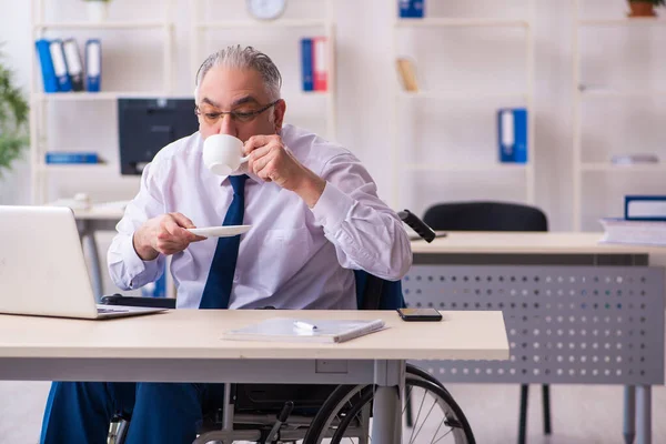 Viejo empleado masculino en silla de ruedas bebiendo café durante el descanso —  Fotos de Stock