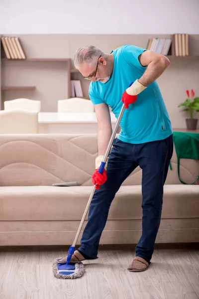 Old man cleaning the house — Stock Photo, Image