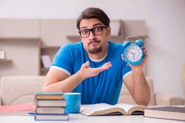 Genç erkek öğrenci zaman yönetimi konseptinde çalışıyor.