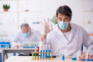 Laboratuvarda uyuşturucu sentezi konseptinde iki erkek kimyager.