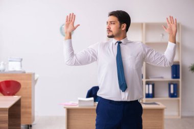 Mola sırasında spor yapan genç erkek çalışanlar.