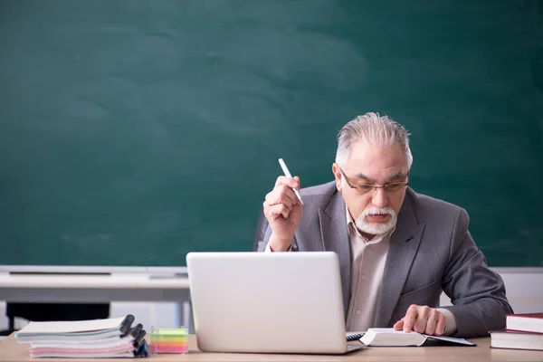 Oude mannelijke leraar voor schoolbord — Stockfoto