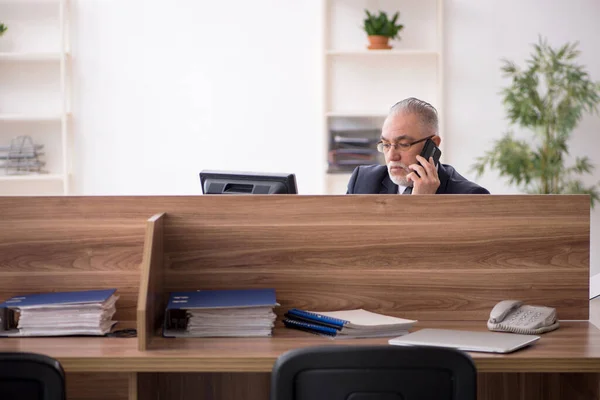 Věk muž zaměstnanec sedí na pracovišti — Stock fotografie