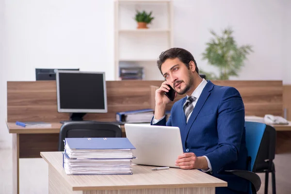 Jeune employé masculin et trop de travail au bureau — Photo