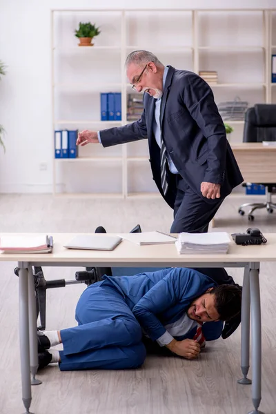 Old boss and young male employee in bullying concept — Stock Photo, Image