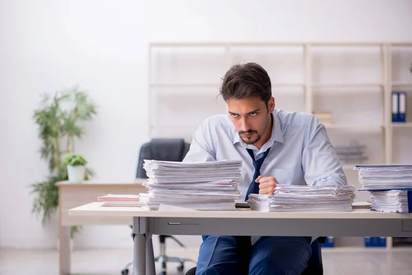 Jeune employé masculin mécontent du travail excessif au bureau — Photo