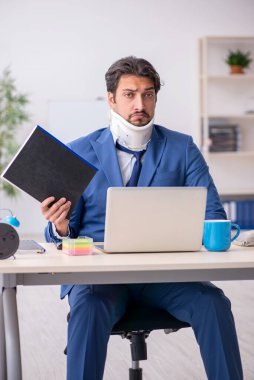 İş yerinde otururken geçirdiği kazadan sonra genç bir erkek.