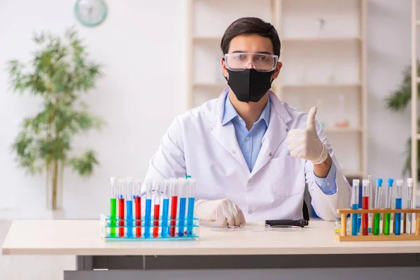 Jovem químico do sexo masculino que trabalha no laboratório durante a pandemia — Fotografia de Stock