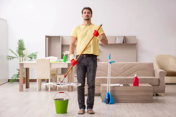 Jovem empreiteiro limpando a casa — Fotografia de Stock