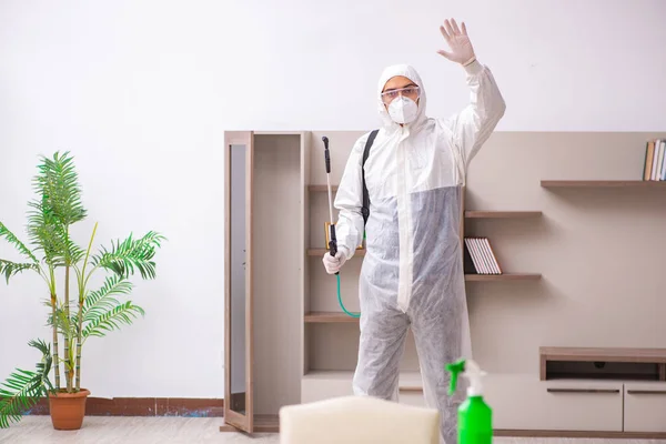 Jovem empreiteiro fazendo controle de pragas em casa — Fotografia de Stock