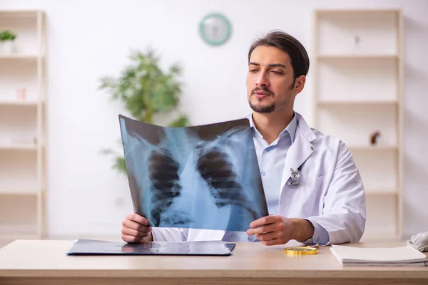 Ung manlig röntgenläkare som arbetar på kliniken — Stockfoto