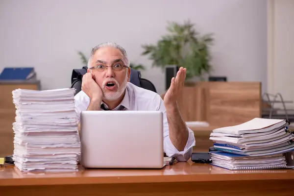 Velho empregado masculino e muito trabalho no escritório — Fotografia de Stock