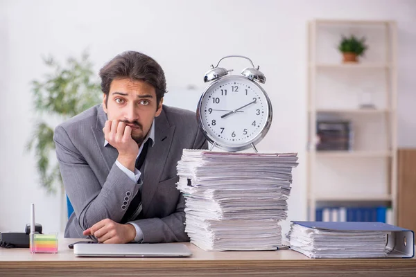 Fiatal férfi alkalmazott az időgazdálkodás koncepciójában a munkahelyen — Stock Fotó