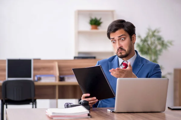 Junge männliche Mitarbeiter sitzen am Arbeitsplatz — Stockfoto