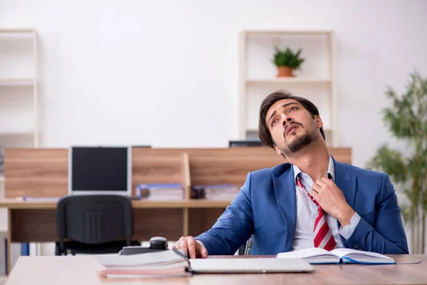 Jovem trabalhador masculino sentado no local de trabalho — Fotografia de Stock