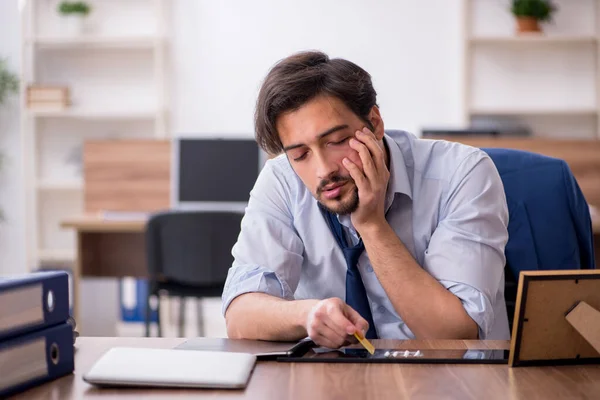 Giovane dipendente tossicodipendente maschile sul posto di lavoro — Foto Stock