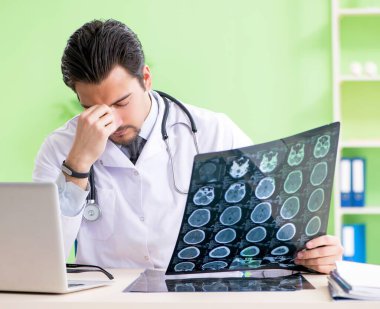 Doktor radyoloji uzmanı hastanede röntgen taramasına bakıyor.