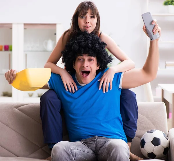 Joven hombre viendo fútbol con su esposa en casa —  Fotos de Stock