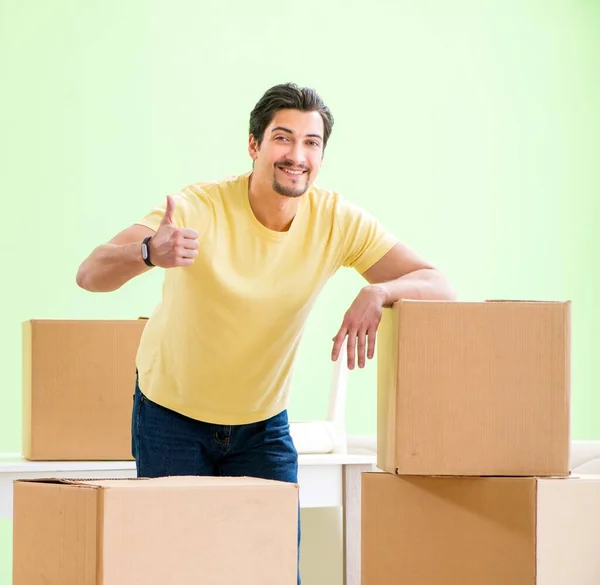 Fiatal, jóképű férfi beköltözik egy új házba dobozokkal. — Stock Fotó
