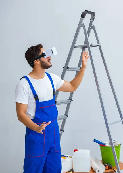 VR gözlüklü, duvar kağıdı yapıştıran bir adam. — Stok fotoğraf