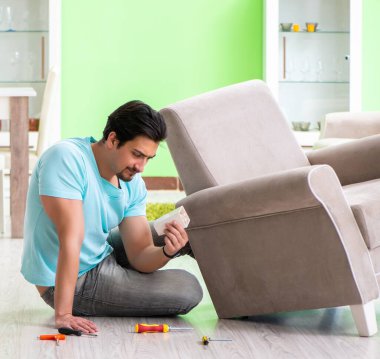 Evdeki mobilyaları tamir eden adam