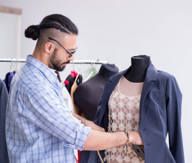 Yeni tasarımlar üzerinde çalışan erkek terzi.