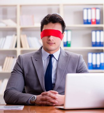 Ofiste masasında oturan gözü bağlı iş adamı.