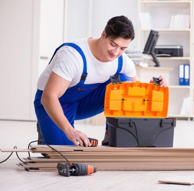 Zemin kaplamalarında çalışan genç bir işçi.