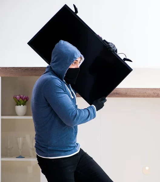 Homme cambrioleur voler le téléviseur de la maison — Photo