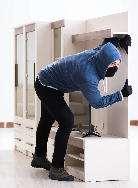 Człowiek włamywacz kradnie telewizor z domu — Zdjęcie stockowe