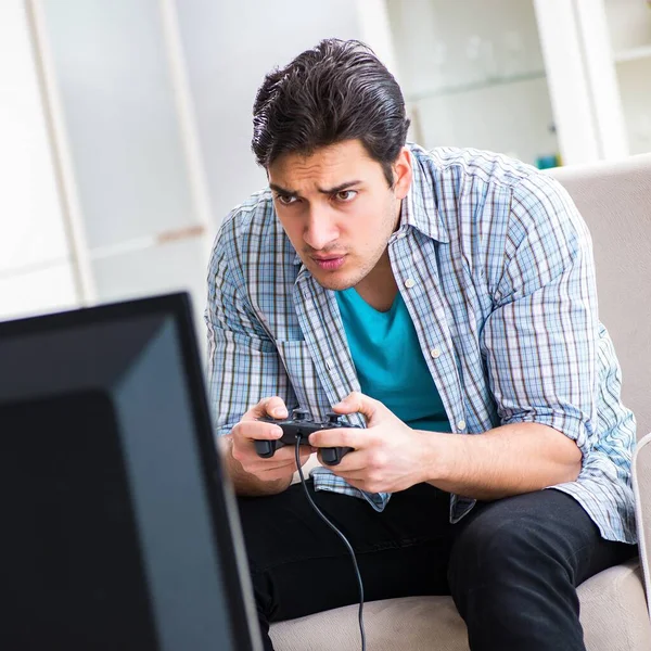 Człowiek gra w grę komputerową w domu — Zdjęcie stockowe
