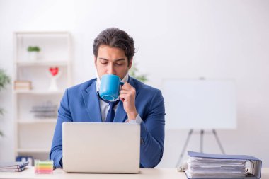 İş yerinde otururken geçirdiği kazadan sonra genç bir erkek.