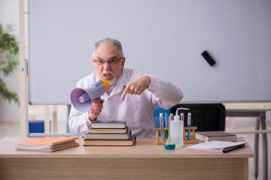 Sınıftaki yaşlı erkek kimyacı öğretmen.