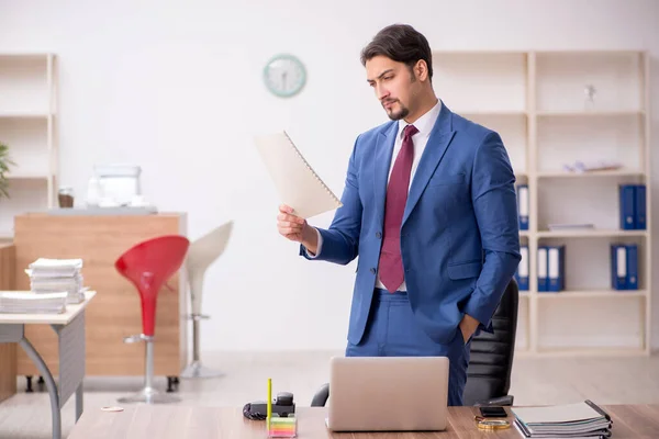 Jovem trabalhador masculino sentado no local de trabalho — Fotografia de Stock